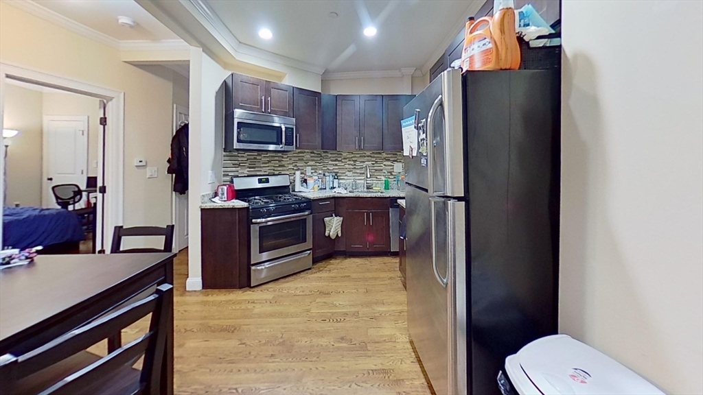 2975 Washington Street, Unit 1 Boston, MA 02119 - Photo 2 of 8 a kitchen with stainless steel appliances a refrigerator and a stove