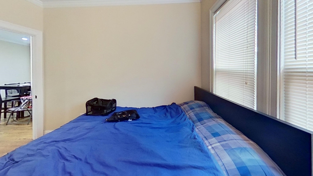 2975 Washington Street, Unit 1 Boston, MA 02119 - Photo 5 of 8 a bed sitting in a bedroom next to a window