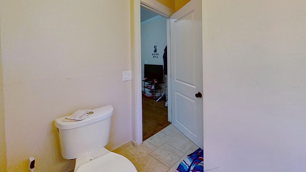 2975 Washington Street, Unit 1 Boston, MA 02119 - Photo 6 of 8 a white toilet sitting next to a bathroom sink and vanity
