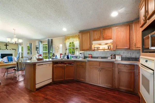 a kitchen with stainless steel appliances granite countertop wooden cabinets a sink and a refrigerator