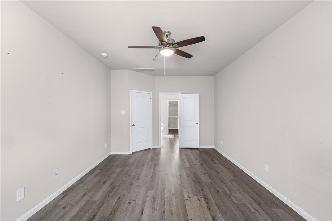974 Harper Lane Bryan, TX 77803 - Photo 18 of 38 Unfurnished bedroom with dark wood-style flooring and a ceiling fan