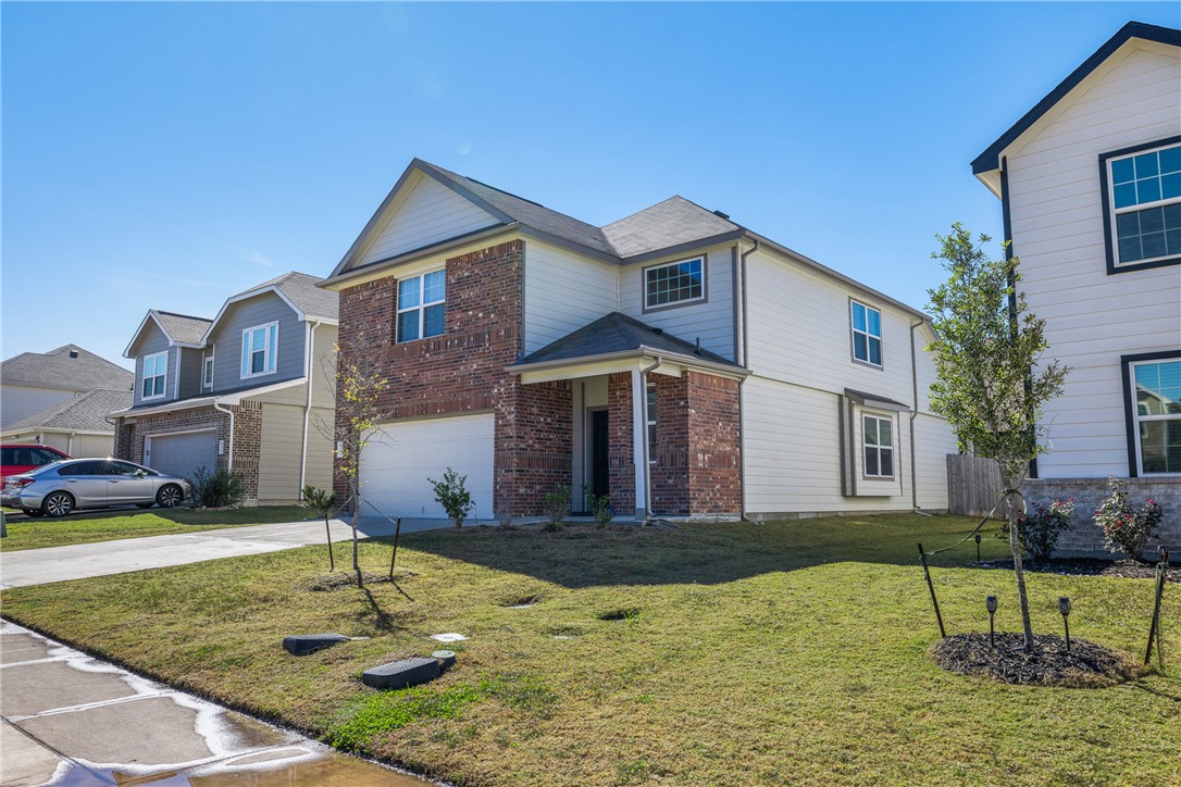 974 Harper Lane Bryan, TX 77803 - Photo 2 of 38 Traditional-style home featuring driveway, a front yard, brick siding, and an attached garage