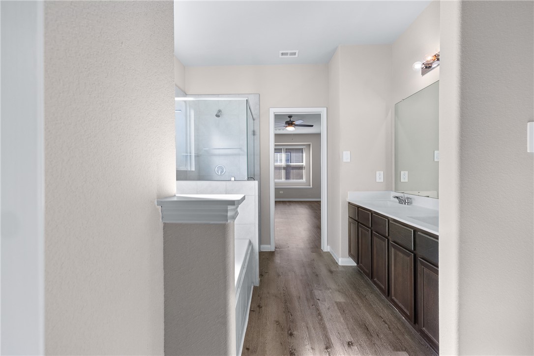 974 Harper Lane Bryan, TX 77803 - Photo 21 of 38 Bathroom featuring light wood-type flooring, vanity, a shower stall, a bath, and a ceiling fan