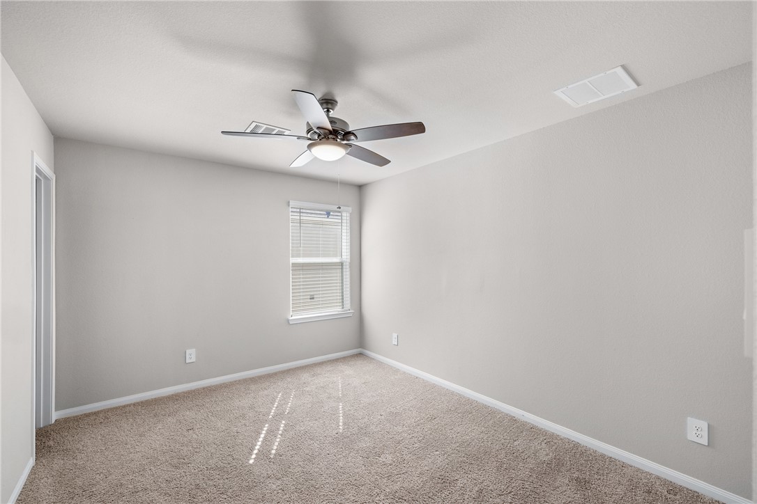974 Harper Lane Bryan, TX 77803 - Photo 28 of 38 Carpeted spare room with baseboards and a ceiling fan