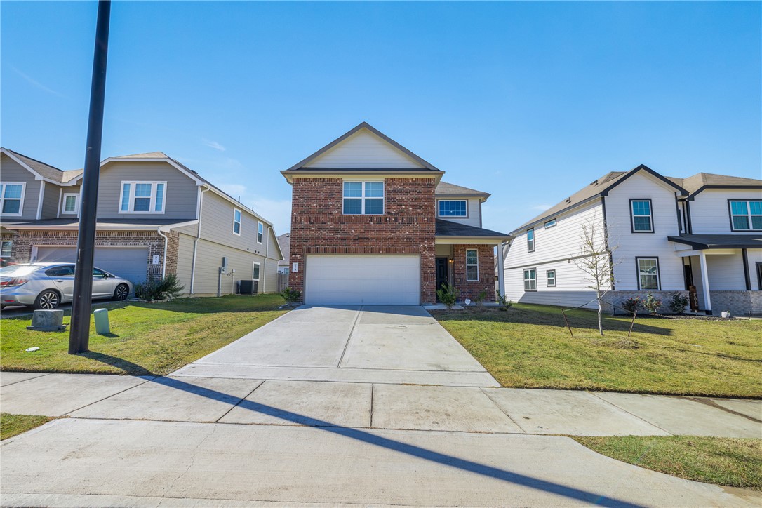 974 Harper Lane Bryan, TX 77803 - Photo 3 of 38 View of front of home with brick siding, driveway, a front yard, and a garage
