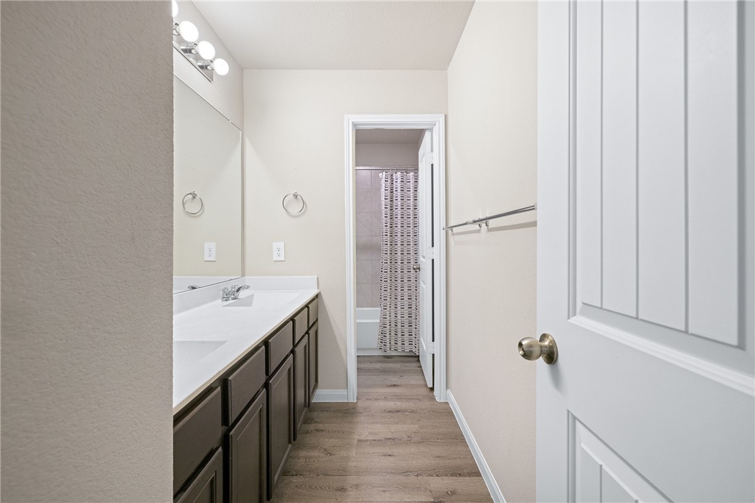 974 Harper Lane Bryan, TX 77803 - Photo 32 of 38 Bathroom with double vanity, light wood finished floors, and shower / bath combo