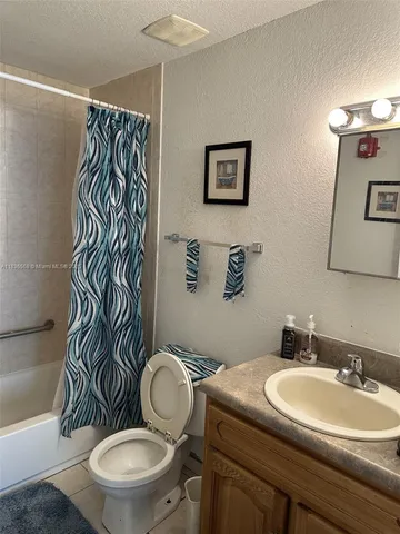 a bathroom with a sink a toilet a mirror and shower
