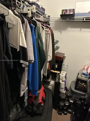 a view of walk in closet with clothes and shoes
