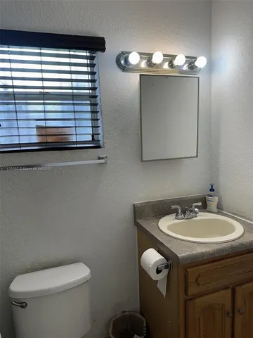 a bathroom with a toilet a sink and mirror