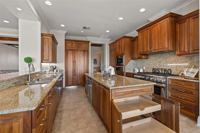 a kitchen with stainless steel appliances granite countertop a stove a sink a refrigerator a dining table and chairs