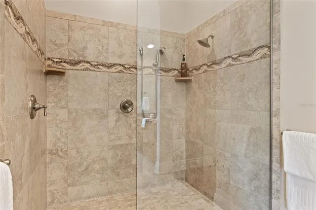 an empty room with wooden floor chandelier and windows