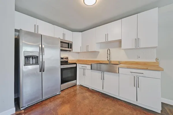 a large kitchen with cabinets and stainless steel appliances