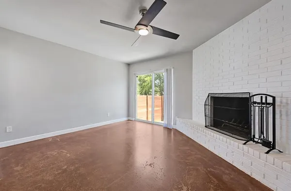 a view of an empty room with windows and a fireplace