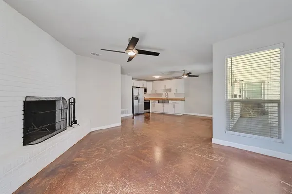 a view of a livingroom with a flat screen tv wooden floor and a ceiling fan