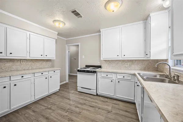 a kitchen with granite countertop a sink stainless steel appliances and cabinets