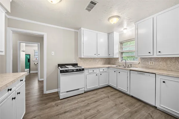 a kitchen with granite countertop white cabinets and appliances