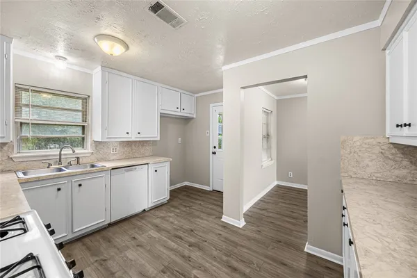 a view of a kitchen cabinets a sink and wooden floor