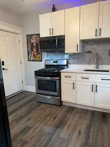 a kitchen with stainless steel appliances a stove a sink and a microwave