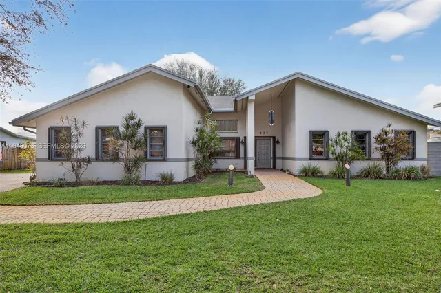 a front view of house with yard and green space