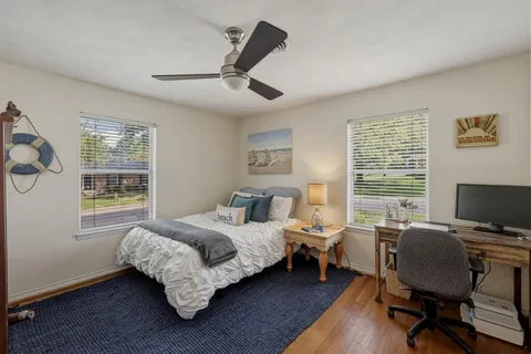 a bedroom with a bed wooden floor and a window