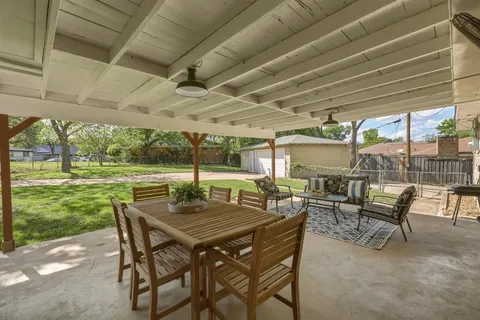 a view of a patio with a table chairs and a backyard