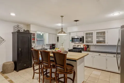 a kitchen with a table chairs refrigerator and cabinets