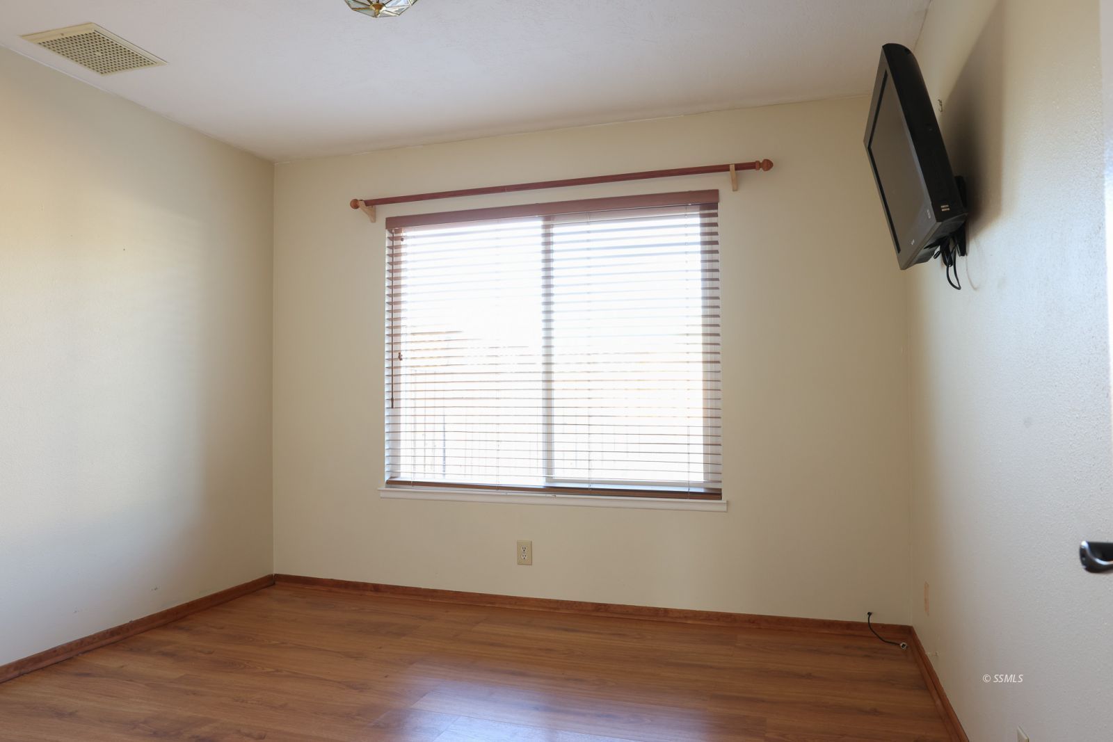 1051 Peg Street Ridgecrest, CA 93555 - Photo 20 of 34 an empty room with wooden floor and windows
