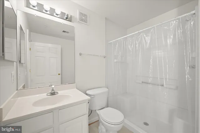 a bathroom with a sink a toilet and shower curtain