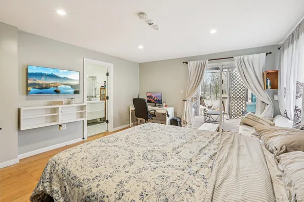 a bedroom with a bed and a flat screen tv