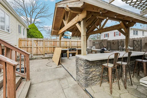 a view of a patio with table and chairs with wooden floor and fence