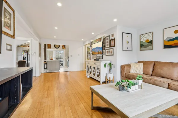 a living room with furniture and large wooden floor