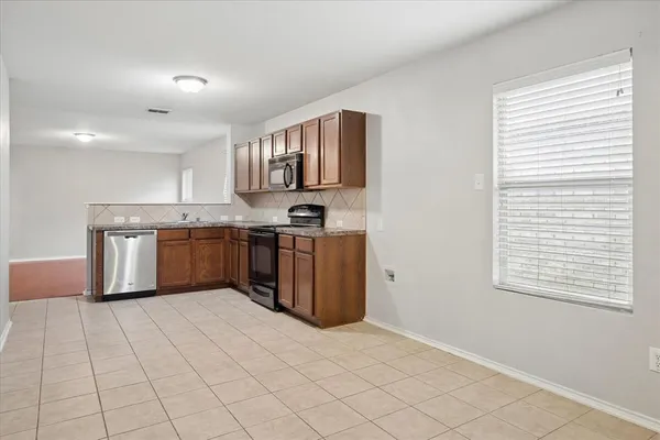a kitchen with stainless steel appliances granite countertop a stove a sink and a microwave