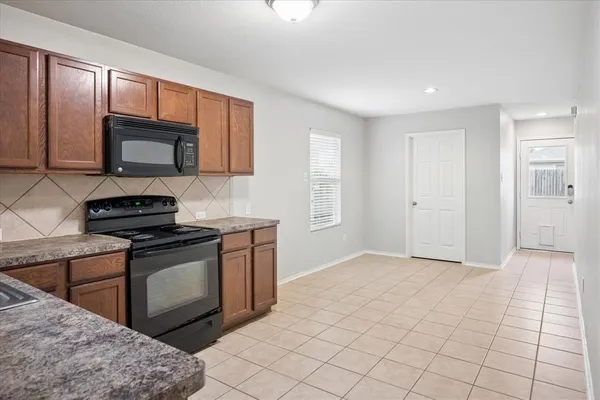 a kitchen with stainless steel appliances granite countertop a stove a sink and a microwave