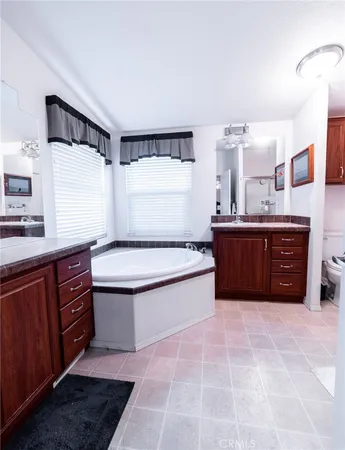 a spacious bathroom with a tub sink and mirror