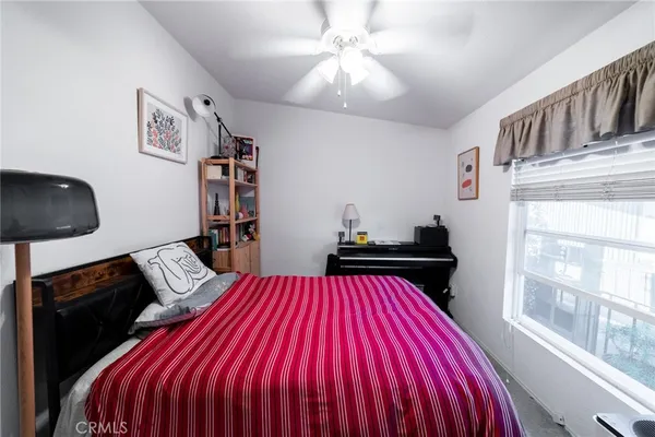 a bedroom with a bed and a flat tv screen on the dresser
