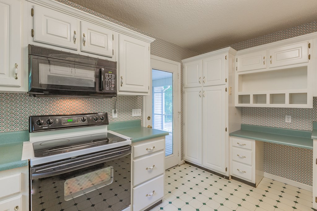 311 Johnson Road Chatsworth, GA 30705 - Photo 25 of 46 a kitchen with granite countertop white cabinets and stainless steel appliances