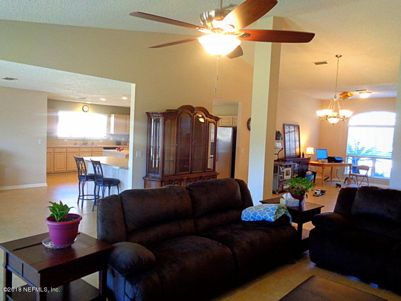 2444 Mallory Hills Road Jacksonville, FL 32221 - Photo 14 of 40 a living room with furniture a chandelier and a dining table
