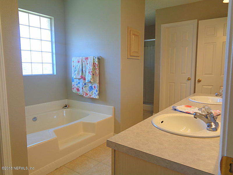 2444 Mallory Hills Road Jacksonville, FL 32221 - Photo 23 of 40 a bathroom with a tub sink and mirror