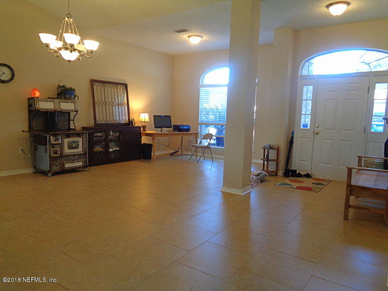 2444 Mallory Hills Road Jacksonville, FL 32221 - Photo 6 of 40 a living room with furniture and a chandelier