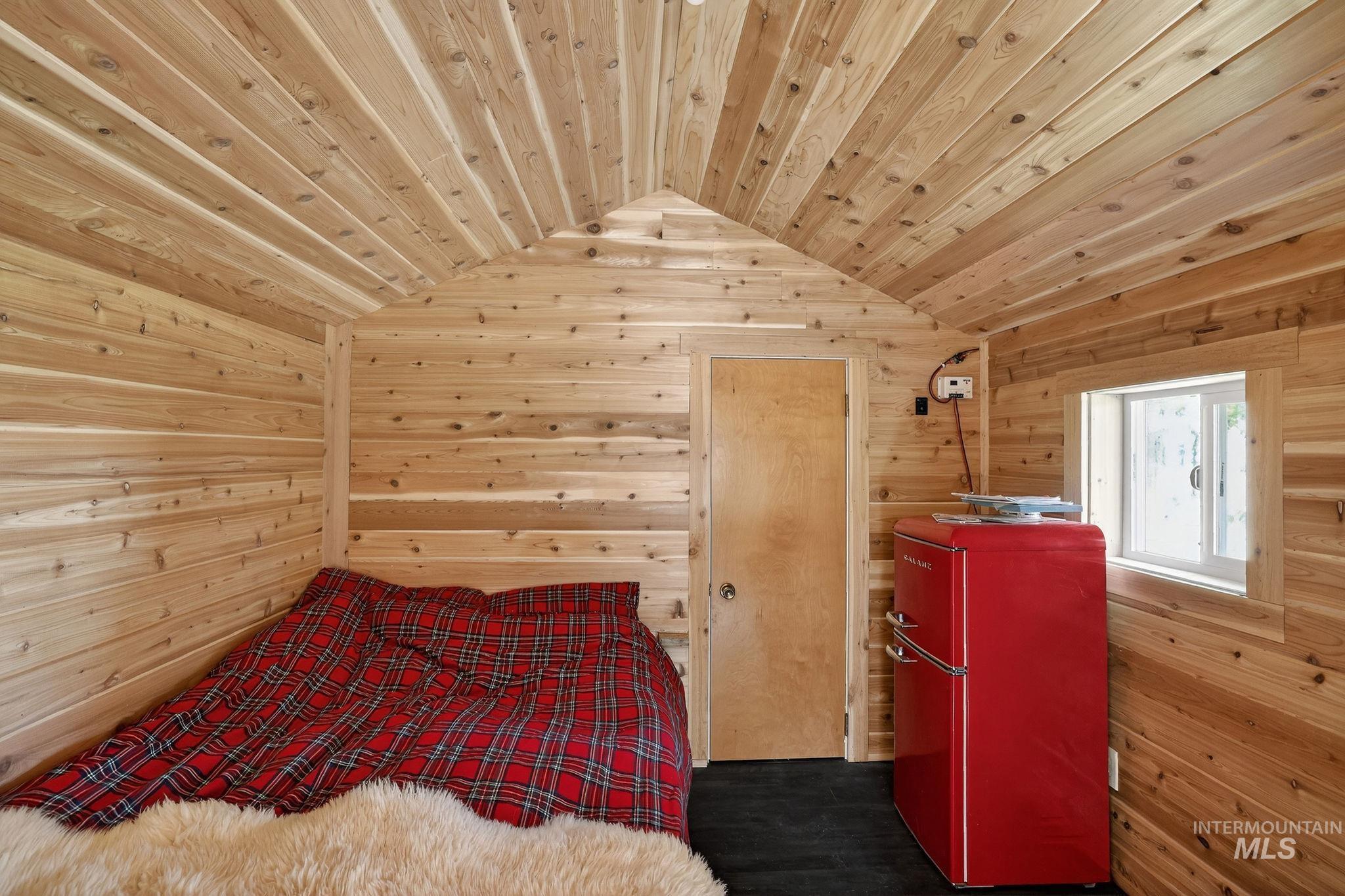 321 Secesh River Road McCall, ID 83638 - Photo 27 of 50 Interior space featuring natural wood-finish wall and ceiling paneling, a vaulted ceiling, a wood-finish door, and a single-pane window