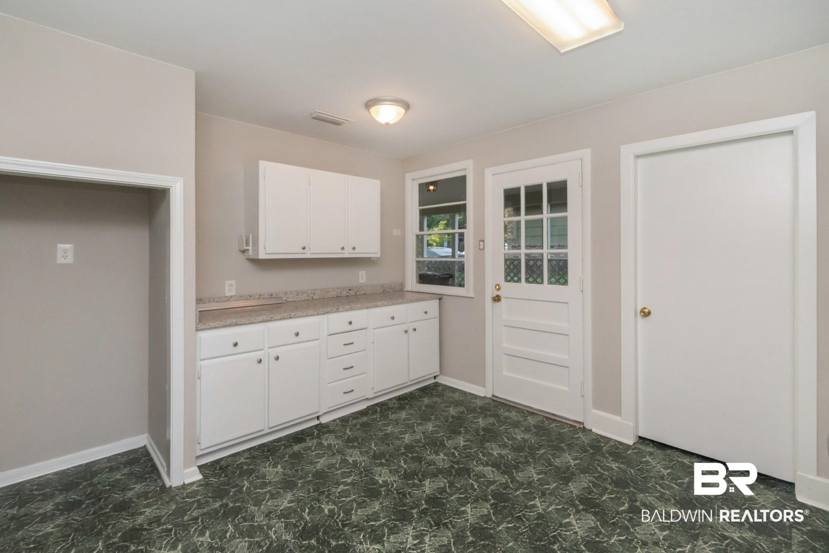 1220 Garland Drive Mobile, AL 36618 - Photo 13 of 25 Kitchen with white cabinetry and dark tile patterned floors