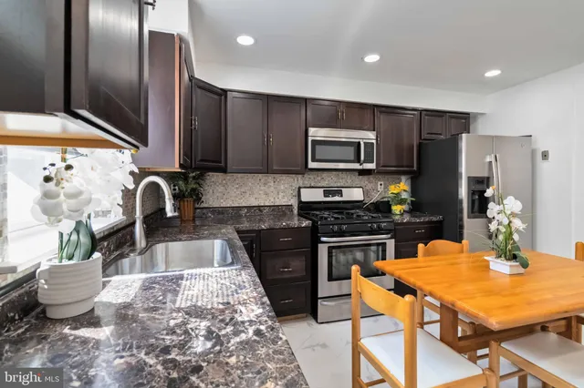 a kitchen with stainless steel appliances granite countertop a stove refrigerator sink and microwave
