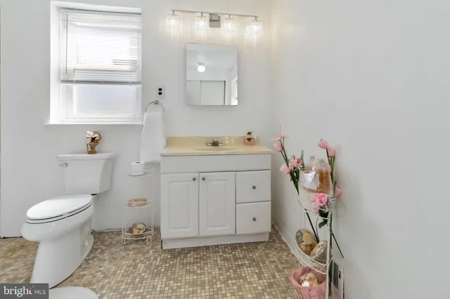 a bathroom with a sink toilet and window