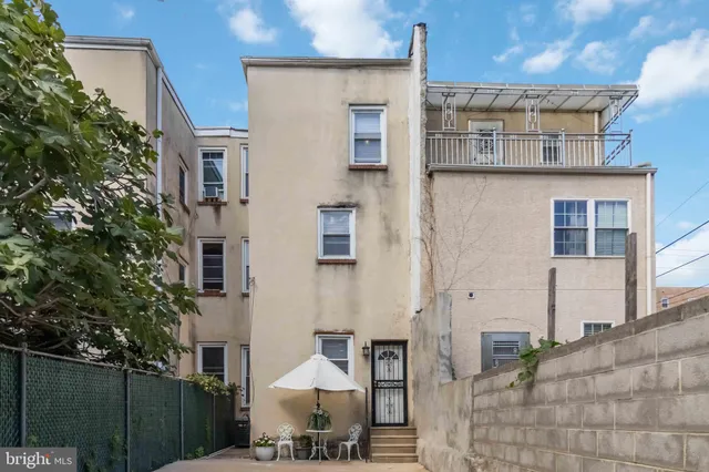 a front view of a building with table and chairs
