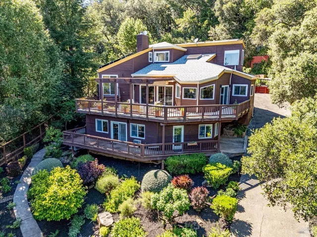 a front view of a house with a big yard and large trees