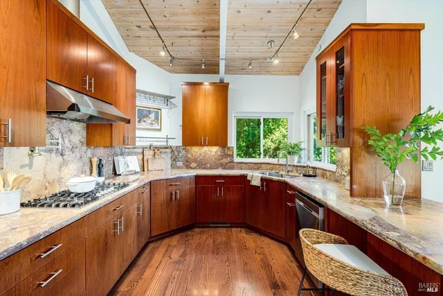 a kitchen with stainless steel appliances granite countertop sink stove and cabinets