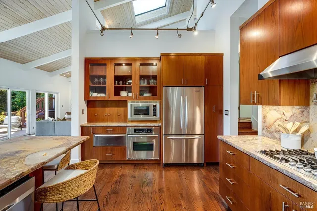a kitchen with stainless steel appliances granite countertop a refrigerator and a stove top oven