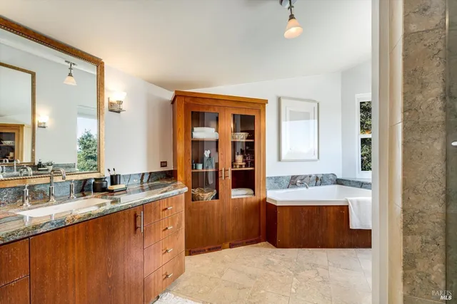 a bathroom with a tub sink and mirror