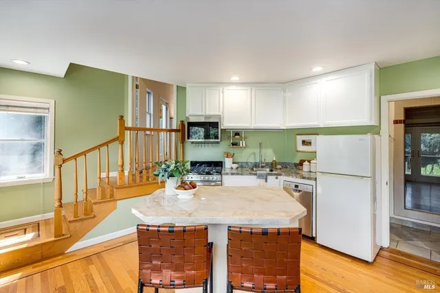 a kitchen with stainless steel appliances kitchen island granite countertop a stove a sink a refrigerator and a microwave