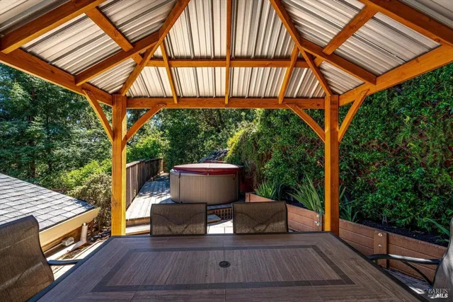 a roof deck with table and chairs under an umbrella
